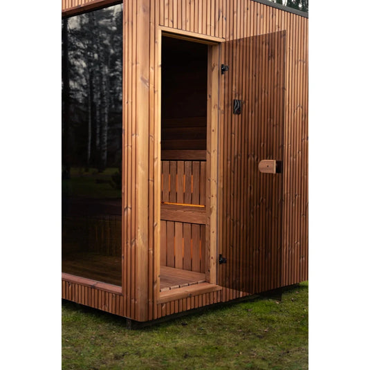 Heritage Lux Dolomiti 4-6 person sauna in a natural outdoor setting with glass door
