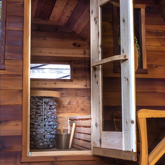 Close-up of flat barrel sauna glass door and wood construction with heater