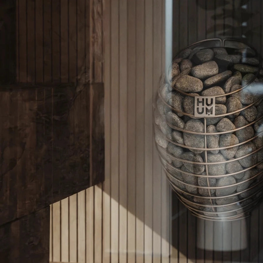 HUUM Drop compact heater in a cozy wood sauna room